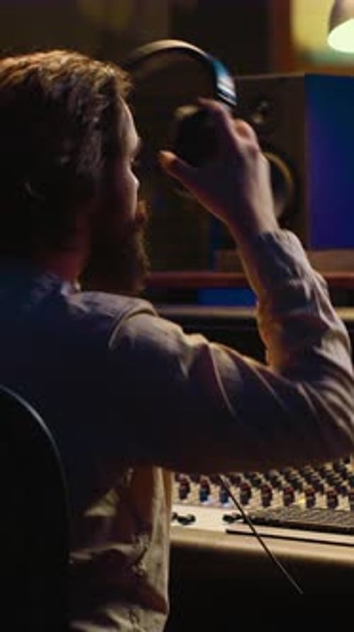 Man Working on Music at Sound Mixer in Studio