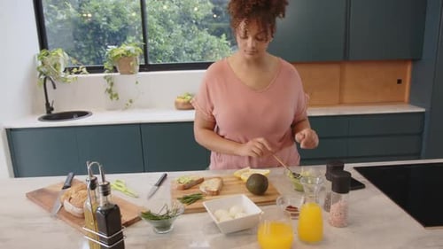 Woman Prepares Delicious Avocado Toast in Modern Kitchen