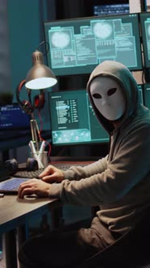 Vertikales Video Männlicher Krimineller trägt Maske und Kapuze, um Computersystem zu hacken