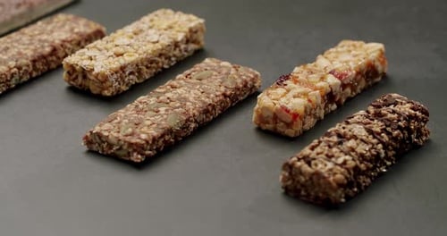 Barritas energéticas variadas sobre fondo oscuro, opciones de bocadillos saludables