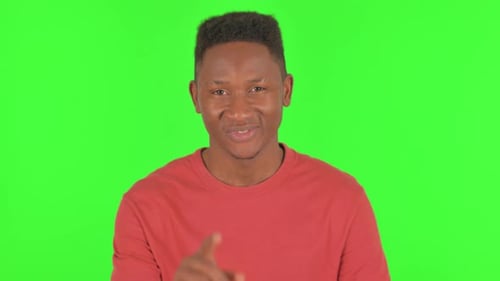 Portrait d'un homme africain invitant des gens sur fond vert