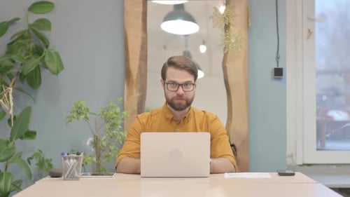 Man Working on Laptop Gives Thumbs Up