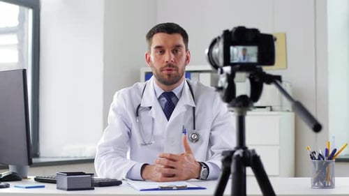 Healthcare, Medicine and Blogging Concept - Male Doctor with Camera Recording Video