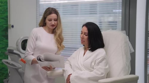 Professional Aesthetician Doctor Consulting Female Client in Modern Cosmetology Clinic Explaining