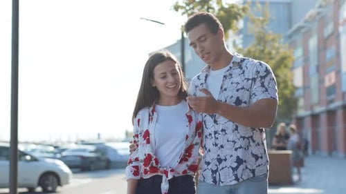 NEW YORK June 10 2018 Attractive Couple Walking in City Center at Sunset Using Mobile Phone Gadget