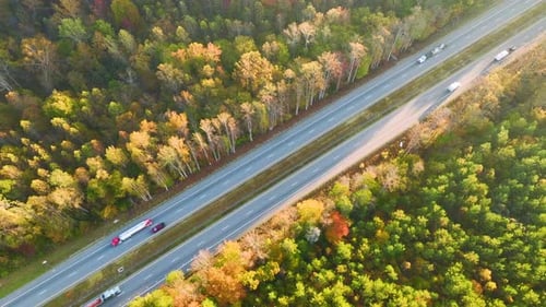 View From Above of Busy American Highway with Fast Moving Traffic Between Autumn Woods