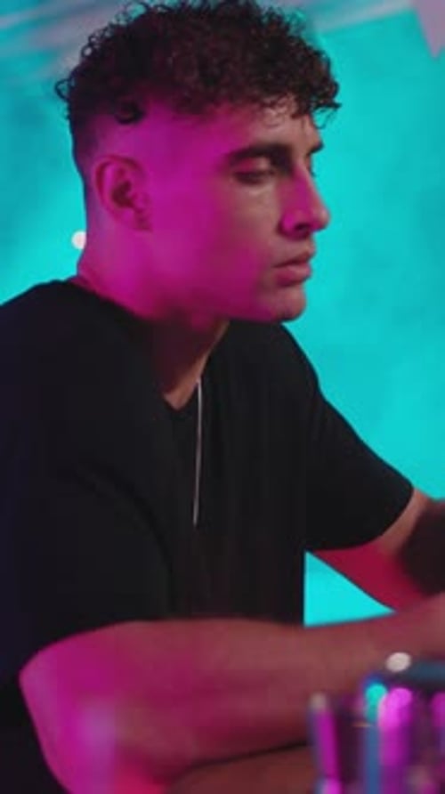 Man with Curls Drinking at Neon Bar