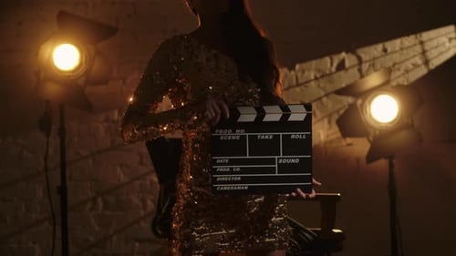 Actress Holding Clapperboard on Film Set in Studio