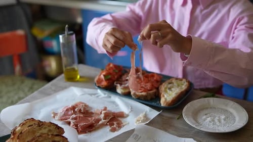 Woman Adding Cured Meat to Open Faced Sandwiches
