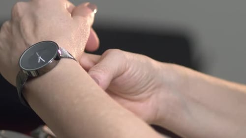Woman Adjusting Modern Watch on Wrist Close Up