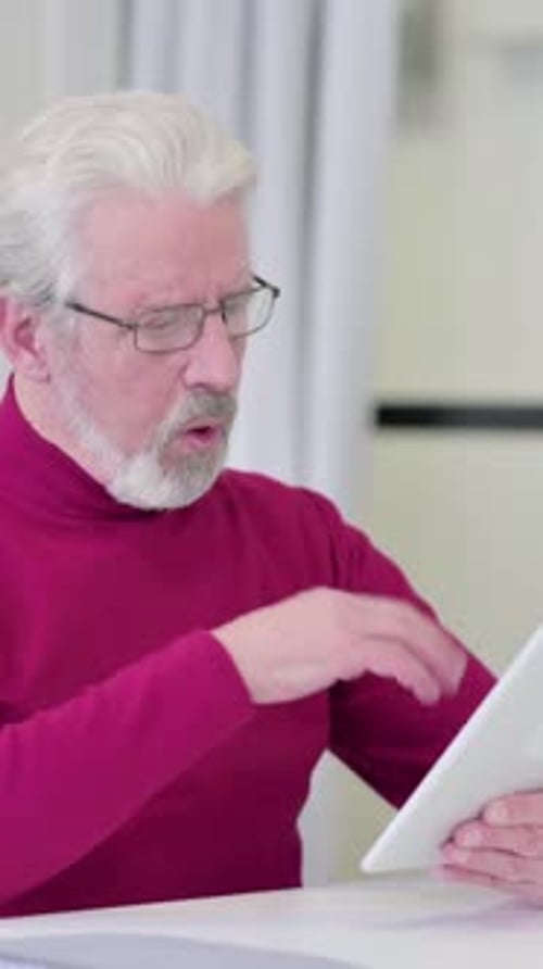 Senior Man Using Tablet Looks Frustrated and Confused