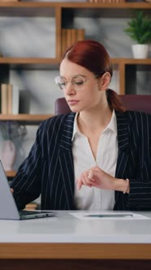 Woman Working at Desk with Laptop in Office