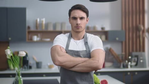 Confident chef with crossed arms in kitchen