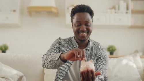Young Black Man Putting Coin in Piggy Bank at Home Portrait of Happy Student Save Money Financial