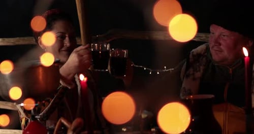 Couple at candlelit table toasting and drinking wine