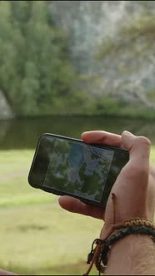 Person Using Map App in Nature Setting