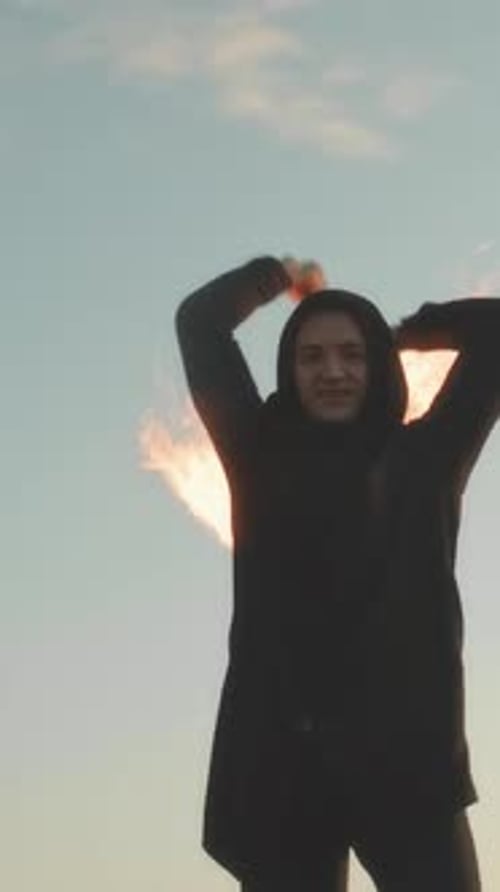 Performer Swinging Flaming Props Outdoors