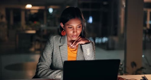 Woman, laptop and review at startup, night and smile with feedback for story at media company