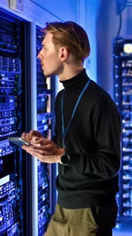 Young Adult Working in Data Center with Tablet