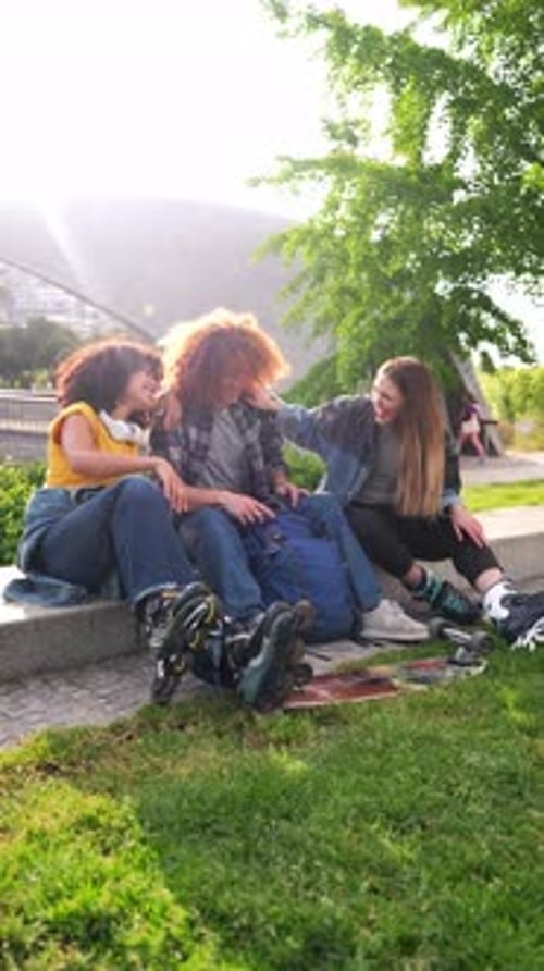 Happy Young People Wearing Inline Skates Relaxing in a Park