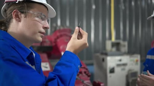 Engineers and technicians working together in a robotic arm factory.