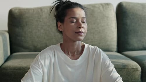 Woman Meditating in Front of Green Couch