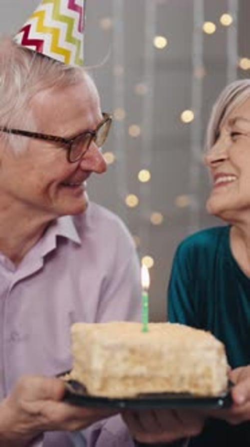 Smiling Senior Couple Celebrating Birthday with Cake