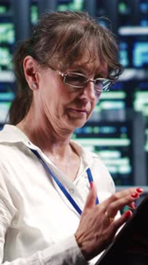 Woman Works on Tablet in Data Center at Night