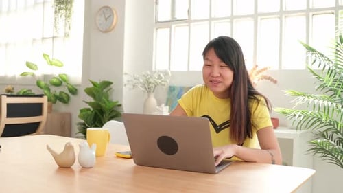 Young Woman Working on Laptop at Home Office