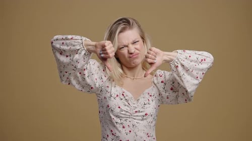 Blonde Woman Gesturing Thumbs Down with Disapproval