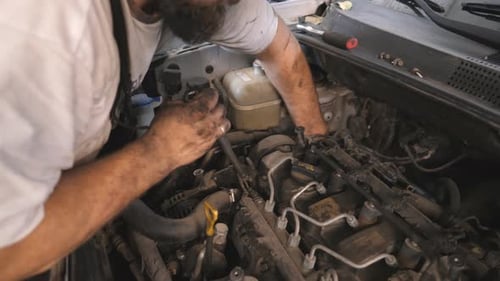 Dirty Hands of Repairman Fixing Engine of a Car at Workshop or Service