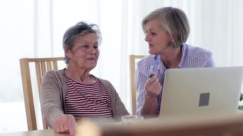 Two senior women looking at laptop computer indoors