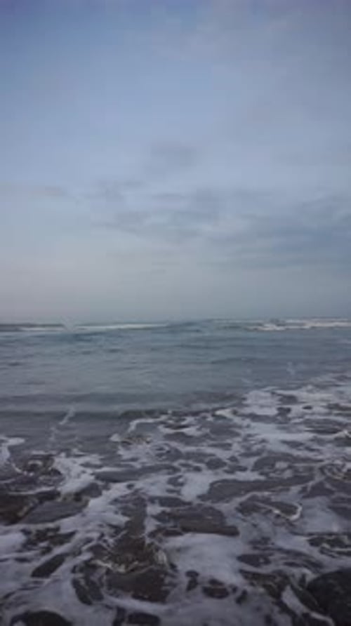 Beautiful vertical beach portrait video in the morning, beautiful view of small waves and beach