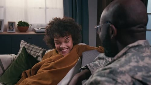 Young Person and Man Talk on Couch