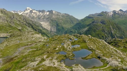 Flight forward over small lakes at Grimselpass in the Swiss alps