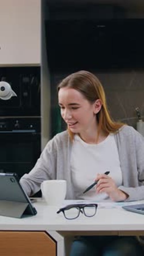 Young Female Entrepreneur Using Laptop Writing Notes in Modern at Home Office Desk Online From Home