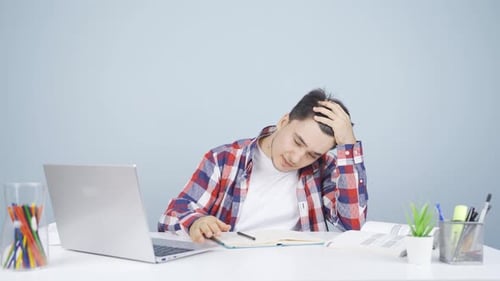 Man looking at laptop gets frustrated.