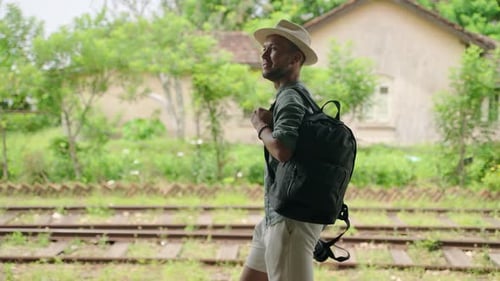 Turista asiático masculino com câmera caminha pela estação ferroviária de Haputale Homem explora a cultura do Sri Lanka