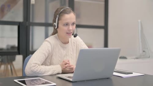 Woman Using Laptop and Headset for Video Call