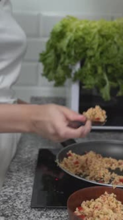 Woman Cooking and Tasting Dish in Home Kitchen