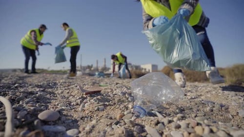 Gruppe von Freiwilligen von Cleanup räumt Müll in der Natur auf und hält einen Müllsack in der Hand