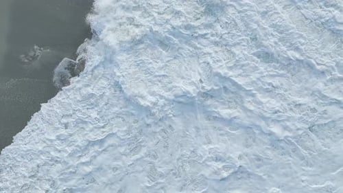 Aerial Video Towering Ocean Waves and Intricate Foam Patterns Dynamically Transform the Scenic Beach