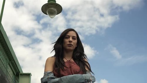 Confident Woman Posing Outdoors Against Blue Sky