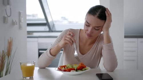 Langweilige Diät, junge, unzufriedene Frau, die gesunden Gemüsesalat isst und sich müde fühlt, zu wählen