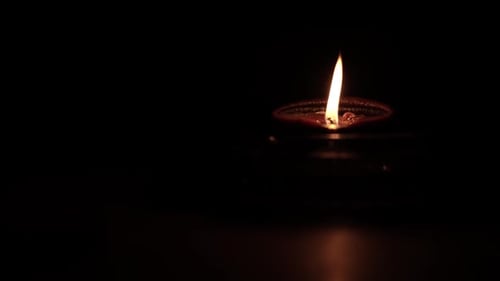 Close Up of Glowing Diya Lamp in Darkness