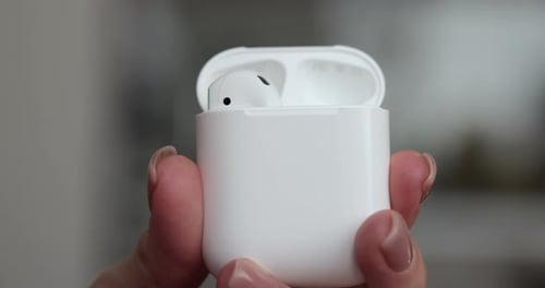 Woman Hands Putting Back the Wireless Earbuds in the Charging Case Close Up