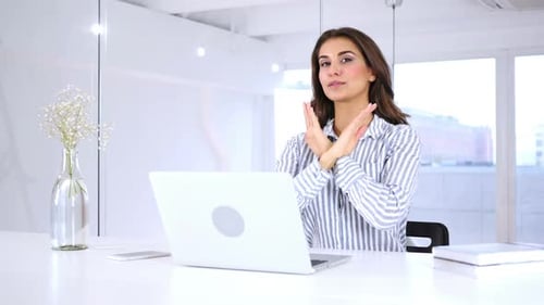 Woman Gesturing No at Desk in Office
