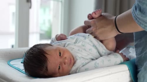 Parent Changes Newborn's Diaper on Changing Table