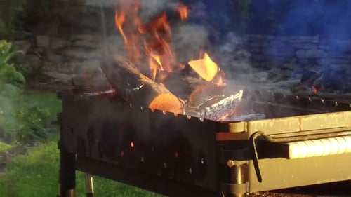 Wood burning in a barbecue grill with smoke