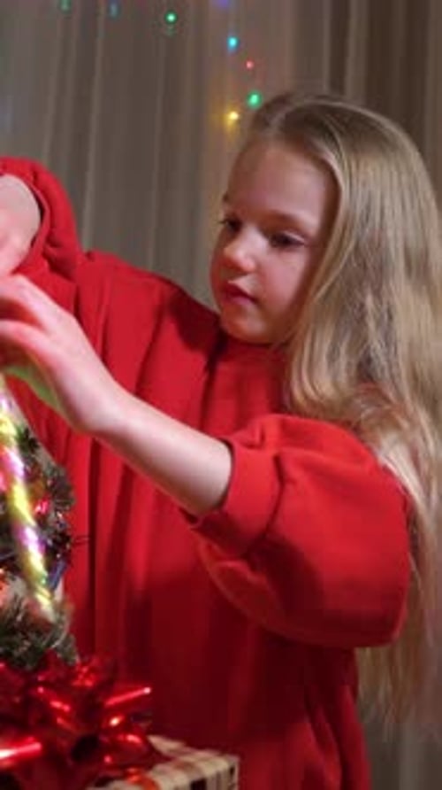 Child Decorating Christmas Tree at Home at Night